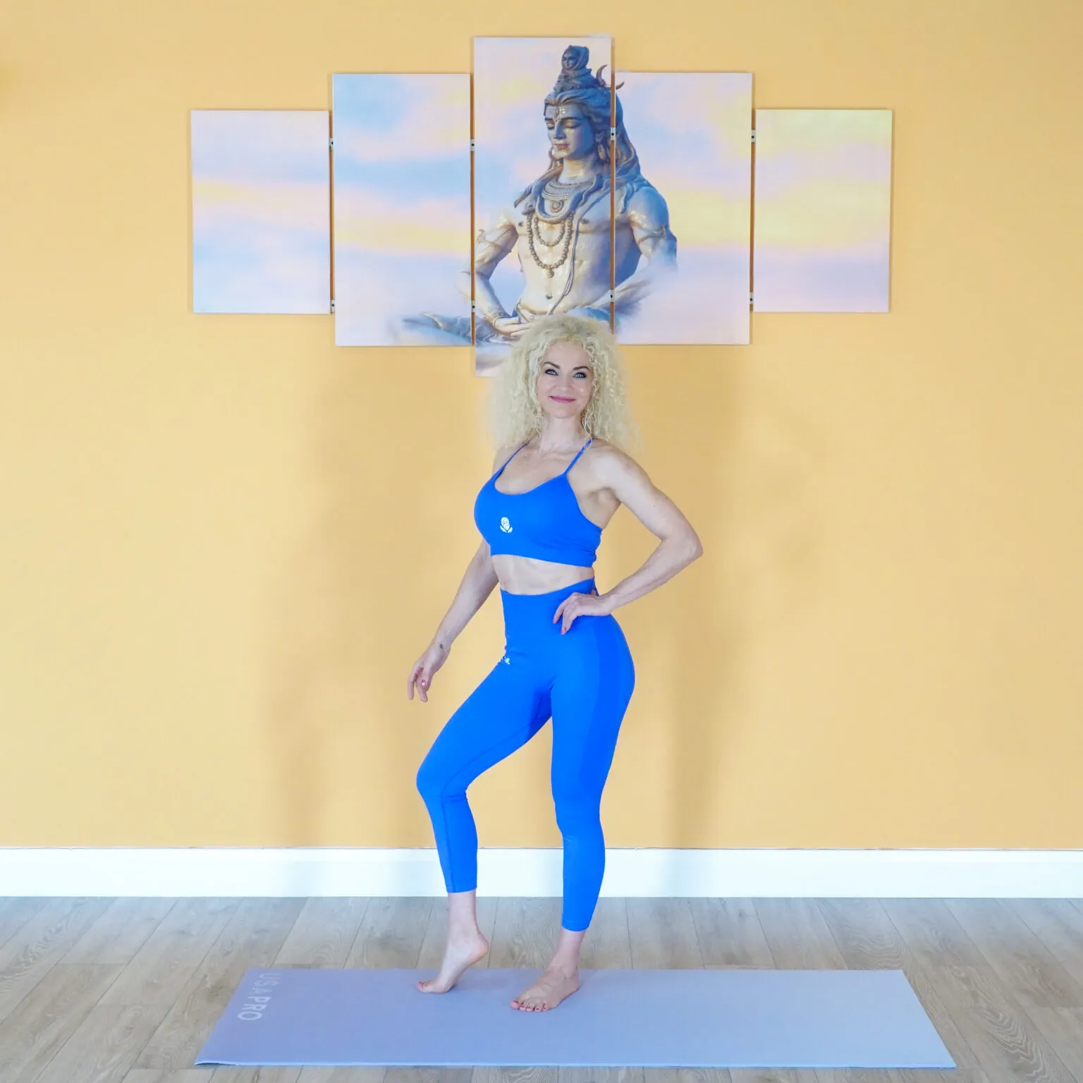 Aniko standing on a yoga mat in her studio